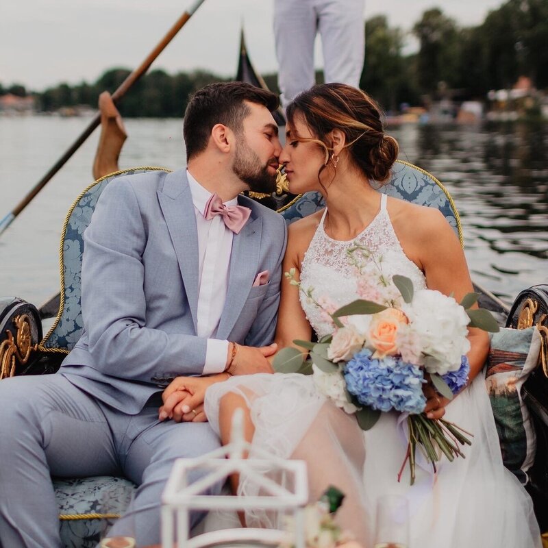 Exklusive Brautfahrt zur Hochzeit in Berlin: Das Brautpaar in einer Hochzeitsgondel auf dem Wasser.
